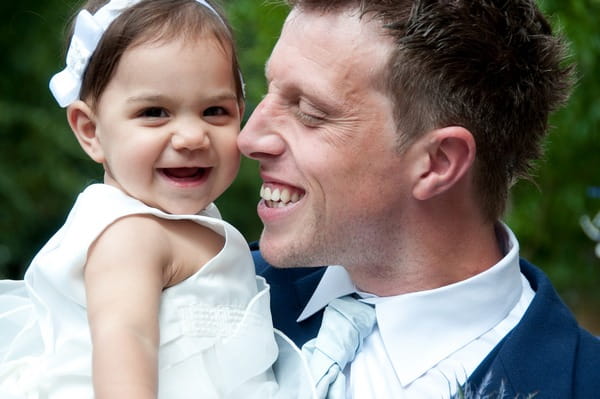 Picture of a groom holding a young girl by Fiona Kelly Photography