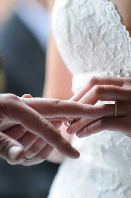 Picture of a bride placing a wedding ring on her groom's finger by Fiona Kelly Photography