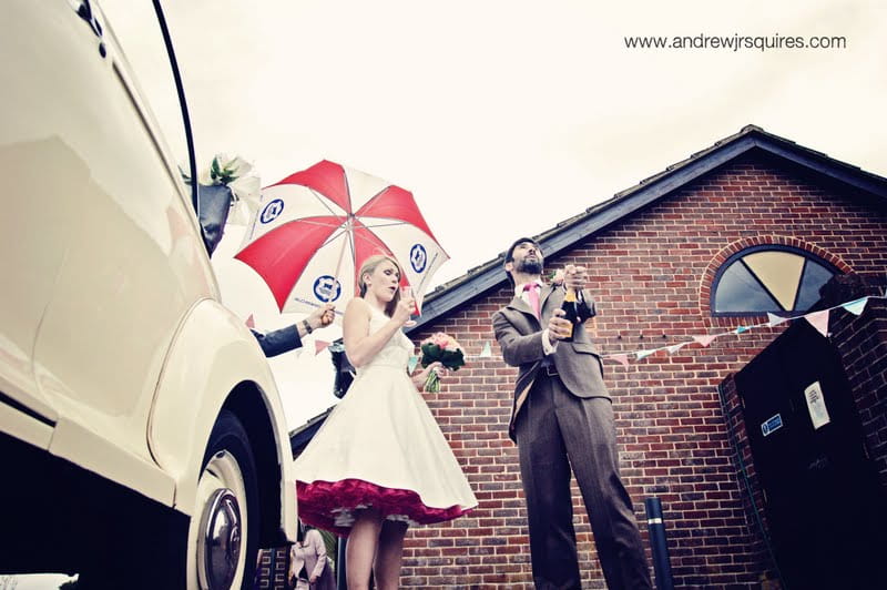 Bride and groom opening a bottle of Champagne by Andrew J R Squires Photography