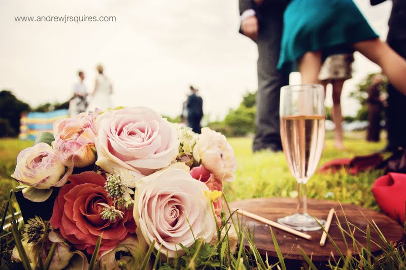 Champage and a bridal bouquet of roses by Andrew J R Squires Photography