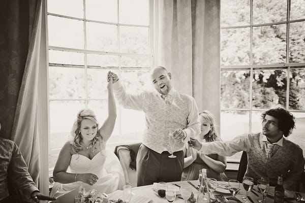 Groom holding his new wife's arm in the air - Martins Kikulis Photography