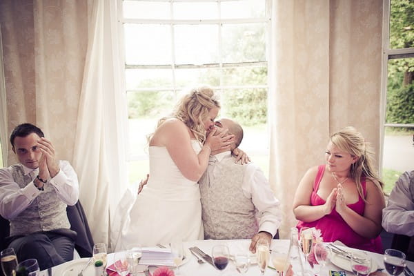 Bride and groom kissing at the top table - Martins Kikulis Photography