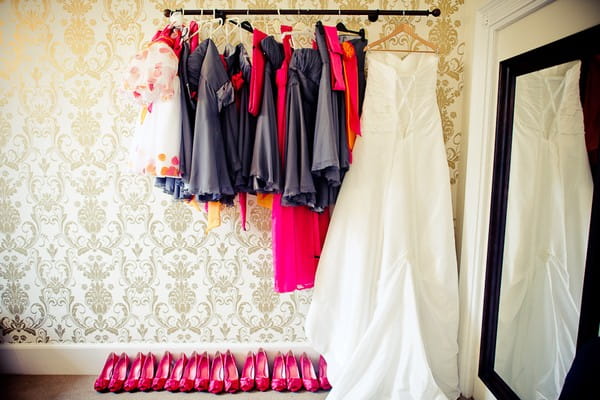 Bridesmaid dresses and wedding gown hanging on a rail - Martins Kikulis Photography