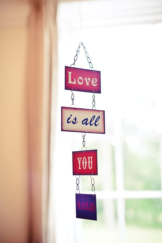 Hanging 'Love is all you need' sign - Martins Kikulis Photography