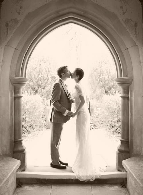 Bride and groom kissing under an arch - Picture by Rebecca Wedding Photography