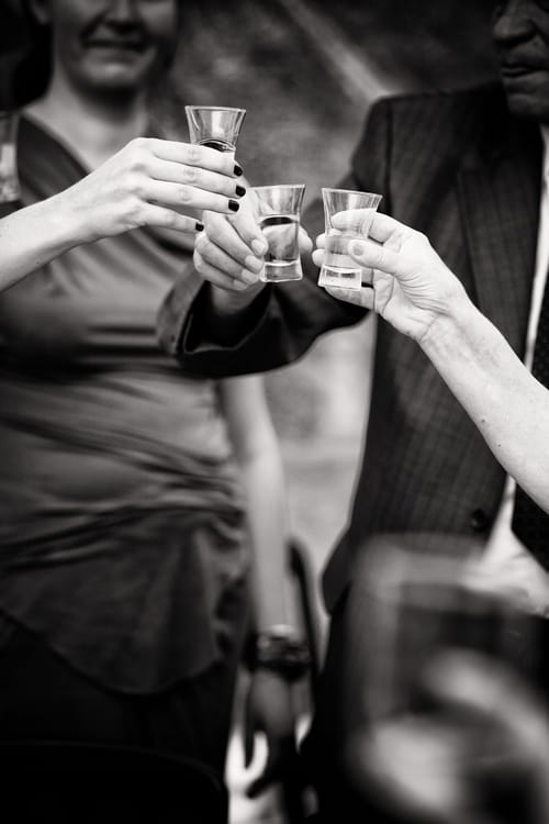 Wedding guests with shots of vodka - Sam Gibson Wedding Photography