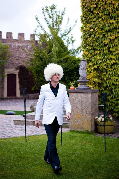 Groom wearing white fluffy hat - Sam Gibson Wedding Photography