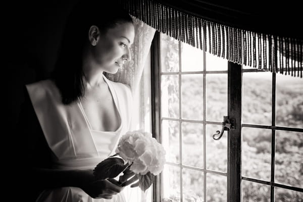 Bride holding her bouquet looking out of the window - Sam Gibson Wedding Photography