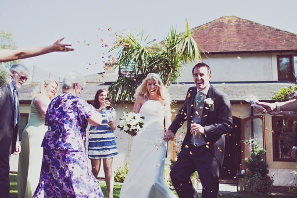 Bride and groom being showered with confetti