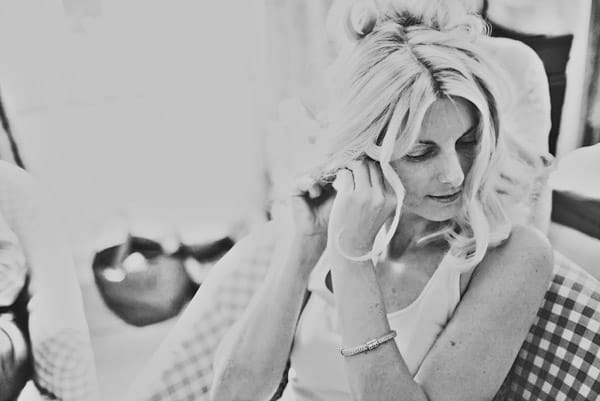 Bride putting earring on