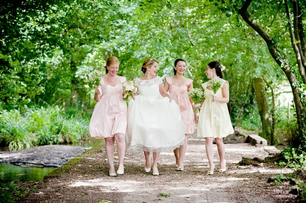 Bride and bridesmaids walking down a woodland lane - Picture by Lemontree Photography