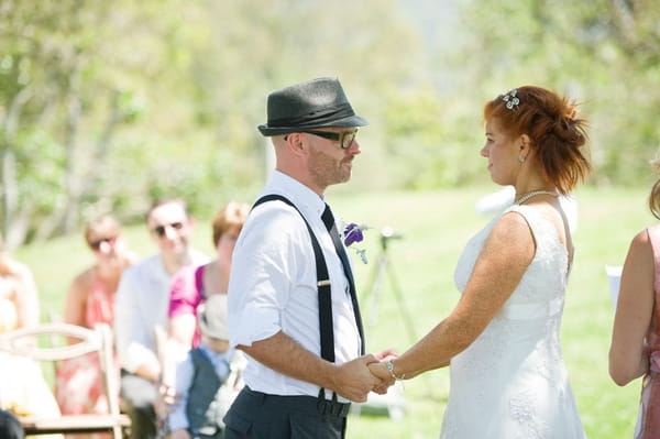 Bride and groom holding hands, saying vows - Picture by Andrea Sproxton Photography