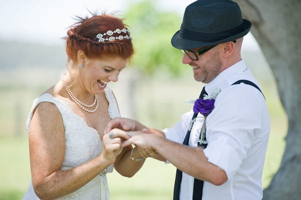 Bride placing ring on groom's finger - Picture by Andrea Sproxton Photography