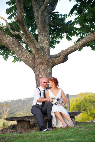 Bride and groom sitting under a tree - Picture by Andrea Sproxton Photography