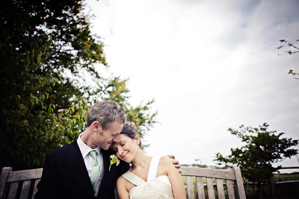 Bride and groom sitting on bench - Picture by Andrew J R Squires Photography