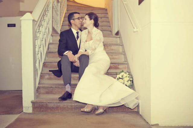 Bride and groom sitting on stairs - Picture by Laura McCluskey Photography