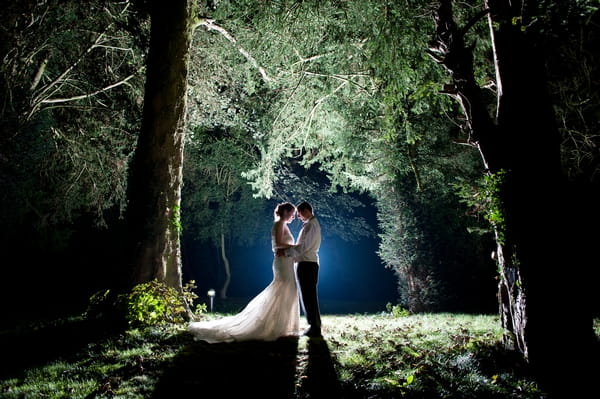 Bride and groom standing in woods in dark - Picture by Lemontree Photography