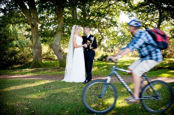 Cyclist riding past bride and groom - Picture by Lemontree Photography