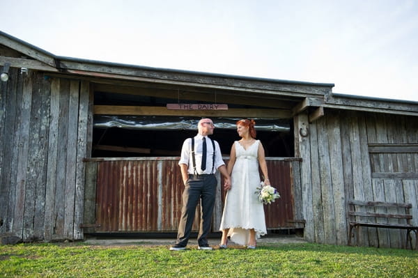 Bride and groom standing outside a dairy - Picture by Andrea Sproxton Photography