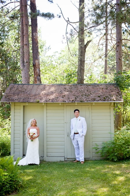 Bride and groom standing in front of shed - Picture by Laura Ivanova Photography