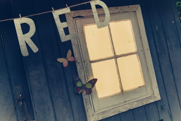 Red letters hanging in front of shed window - Picture by Ian Shoots Weddings