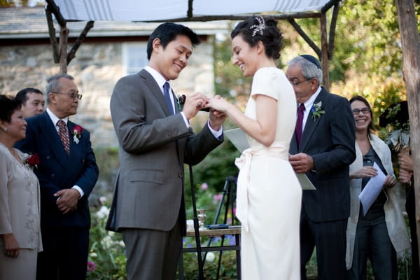 Groom placing ring on bride's finger - Picture by Levi Stolove Photography
