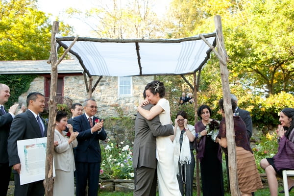 Bride and groom hug under Chuppah - Picture by Levi Stolove Photography