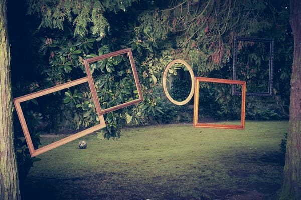 Picture frames hanging from trees - Picture by Ian Shoots Weddings