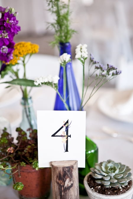 Table number bottles and pot plants on wedding table - Picture by Levi Stolove Photography