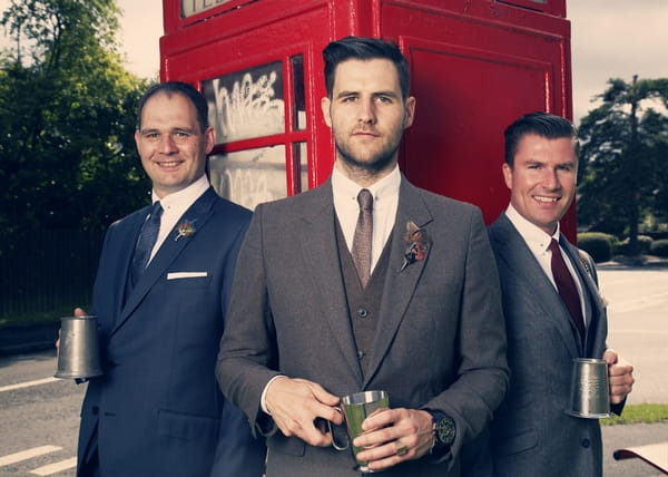 Groomsmen standing in front of a red phone box - Picture by Ian Shoots Weddings