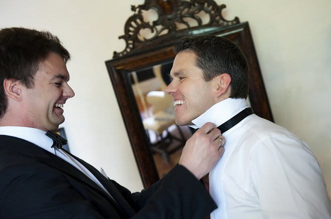 Best man doing up groom's bow tie - Picture by Gill Maheu Photography