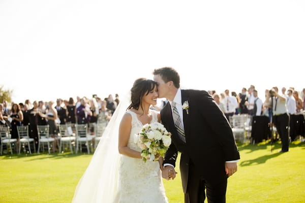 Groom kissing bride on cheek - Picture by Allyson Magda Photography