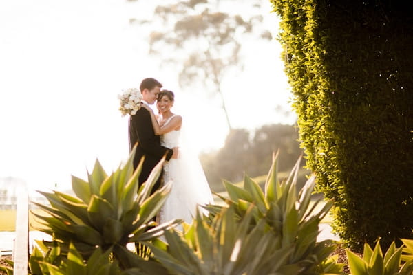 Bride with arms around groom - Picture by Allyson Magda Photography