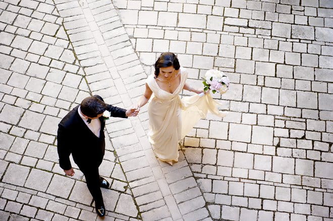 Bride and groom holding hands walking to wedding - Picture by Gill Maheu Photography