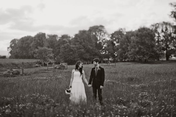 Bride and groom walking in a field - Picture by Jonas Peterson Photography