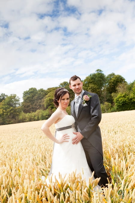 Bride and groom standing in corn field - Picture by Hayley Ruth Photography