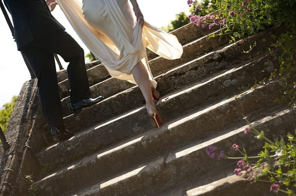 Legs of bride and groom as they walk up steps - Picture by Gill Maheu Photography