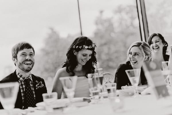 Bride and groom smiling during wedding speech - Picture by Jonas Peterson Photography