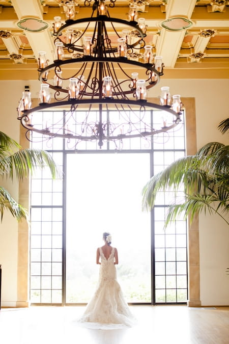 Bride standing in front of large glass window - Picture by Allyson Magda Photography