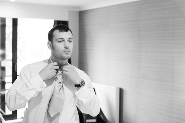 Groom doing up his cravat - Picture by Hayley Ruth Photography