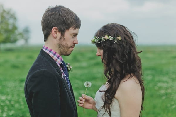 Bride holding dandelion facing groom - Picture by Jonas Peterson Photography