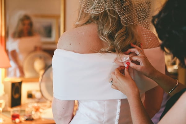 Doing up back of bride's wedding dress - Picture by McKinley-Rodgers Photography