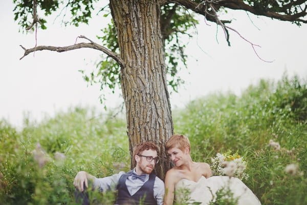 Bride and groom sitting under tree - Picture by Josh Dookhie Photography