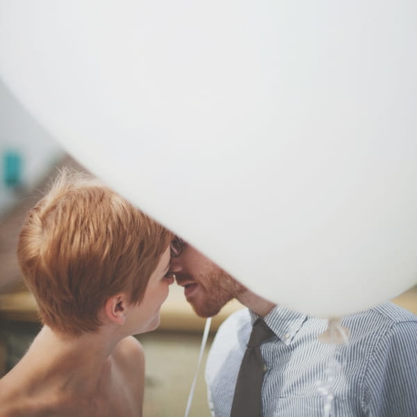 Bride and groom kissing behind balloon - Picture by Josh Dookhie Photography