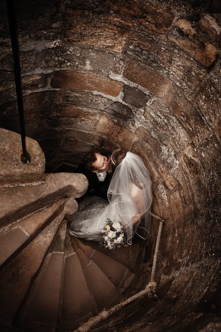 Bride and groom on steps at Dirleton Castle - Picture by Archibald Photography