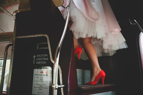 Bride's red shoes as she walks up steps on bus - Picture by McKinley-Rodgers Photography