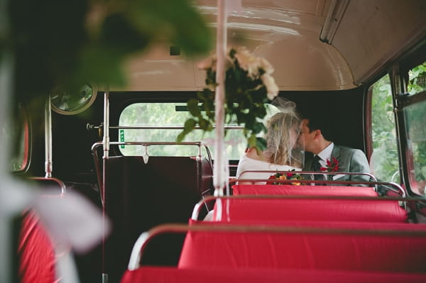 Bride and groom kiss on back seat of bus - Picture by McKinley-Rodgers Photography