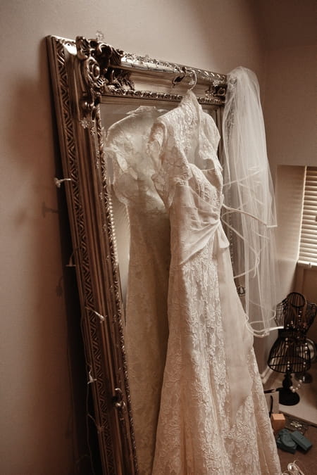 Lace wedding dress hanging on mirror - Picture by Archibald Photography
