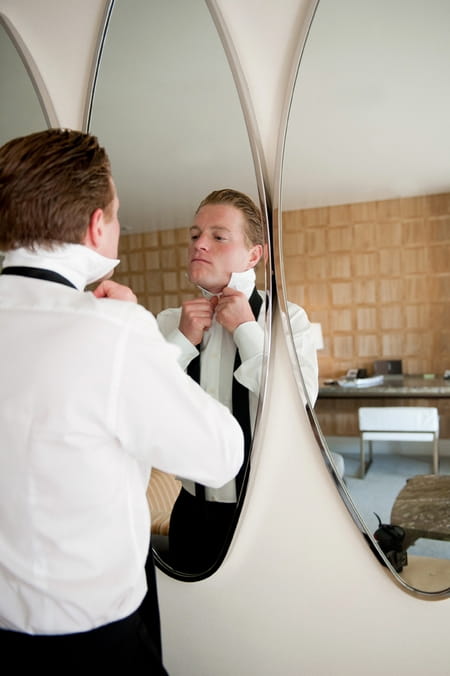 Groom doing up his top button - Picture by Yvette Roman Photography