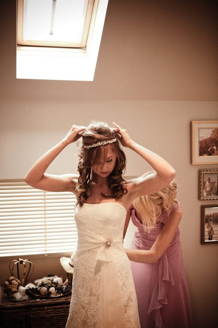 Bridesmaid adjusting bride's dress - Picture by Archibald Photography